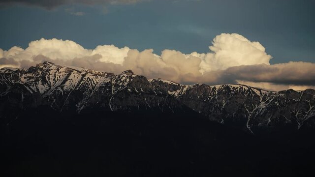 Timelapse with clouds over the Bucegi mountains in Romania during a spring day, as seen from the hills of Pestera village.