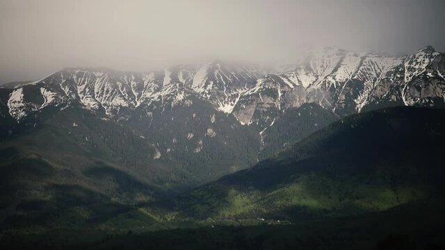 Heavy clouds over the Bucegi mountains in Romania during a spring day, as seen from the hills of Pestera village.