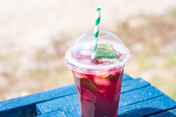 lemonade red soda cherry or strawberry fresh juice, sea coast shore, summer surf wave background refreshing drink relax positive mood vacation top view