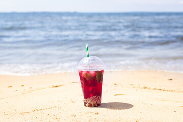 lemonade red soda cherry or strawberry fresh juice, sea coast shore, summer surf wave background refreshing drink relax positive mood vacation top view