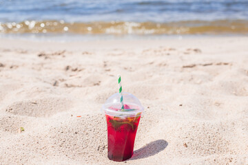 lemonade red soda cherry or strawberry fresh juice, sea coast shore, summer surf wave background refreshing drink relax positive mood vacation top view