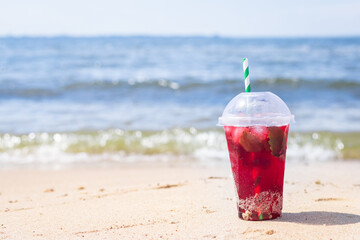 lemonade red soda cherry or strawberry fresh juice, sea coast shore, summer surf wave background refreshing drink relax positive mood vacation top view