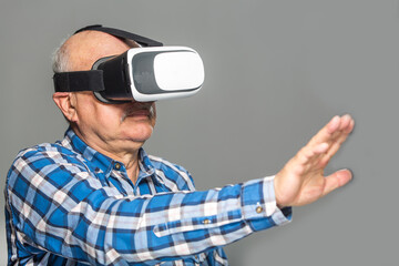Naklejka na ściany i meble Old man in virtual reality glasses over grey background