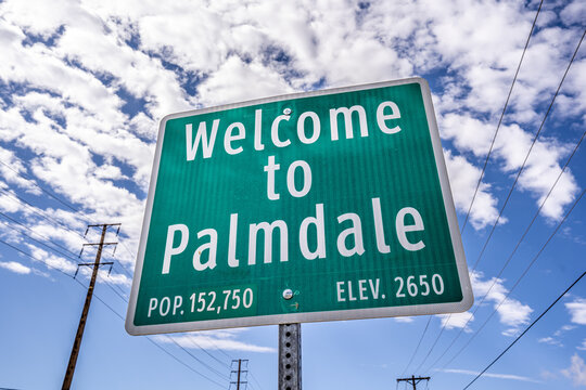 Welcome To Palmdale Green City Sign with Population Blue Sky with Clouds and Power Lines