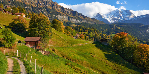 Mountain panorama with the old wooden barn and the high peak of Jungfrau mountain on the background in autumn season in Switzerland.