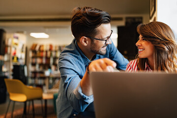 Happy young people working together on laptop. Teamwork, study, technology, office concept