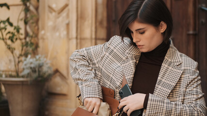 Beautiful stylish businesswoman dressed in plaid blazer hiding s