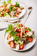 Vertical shot salads with jamon, strawberries, grapes, mozzarella and olives with pomegranate sauce. Healthy and balanced nutrition. Organic food. Mediterranean cuisine recipes. Copy space