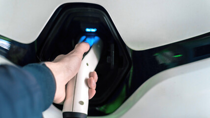 Plugging in charger into an electric car