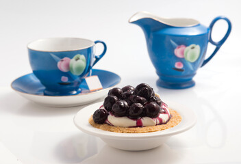 blueberries cheese pie, a cup of tea and milk jar