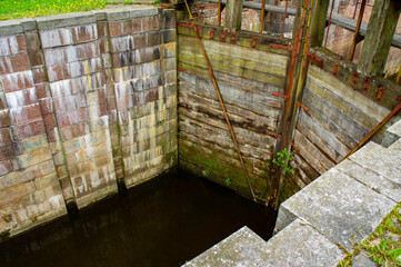 Old navigable river sluice. 20th century architecture with wooden mechanics. Augustow Canal, Belarus, 18 May 2021