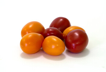 Red and yellow italian tomato fruits on white background with shadows