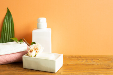 Bathroom bottle, shower towel, soap on wooden table. Skin care and spa concept