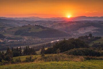Picturesque sunset in Beskid Sądecki seen from the tower in Wola Krogulecka, with views of the mountains and fields. © PawelUchorczak