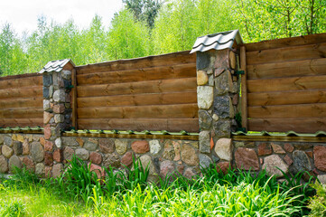 Fototapeta premium Old vintage wooden rustic fence with stone foundation