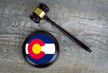 Wooden judgement or auction mallet with of Colorado flag. Conceptual image.