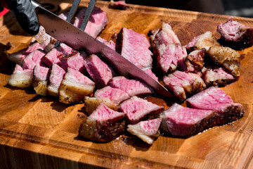 Chef slicing tender medium rare roast beef brisket
