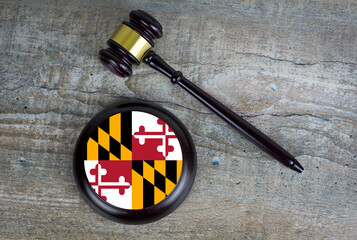 Wooden judgement or auction mallet with of Maryland flag. Conceptual image.