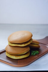selective focus of Japanese pancake named dorayaki in a  brown plate against white background 