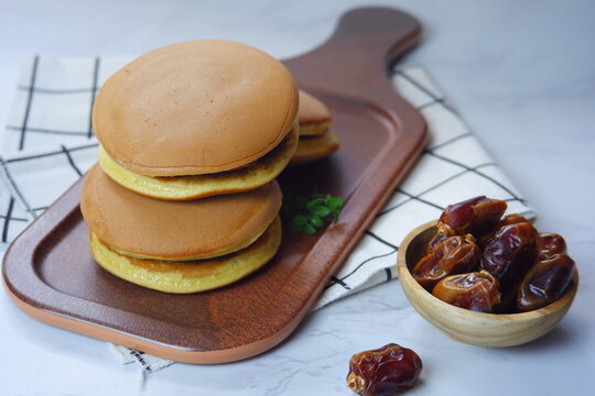 selective focus of Japanese pancake named dorayaki in a  brown plate against white background 