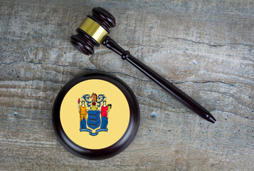Wooden judgement or auction mallet with of New Jersey flag. Conceptual image.