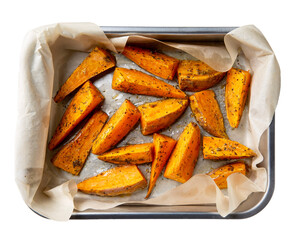 Sweet potato wedges. Oven baked sweet potato with herbs in metal baking dish isolated on white. Healthy vegetarian food concept. Top view.