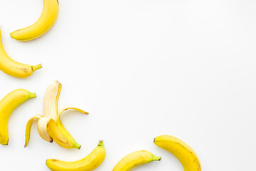 Whole and peeled bananas flay lay. Fruits pattern. Top view