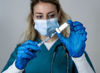 Female doctor or nurse holding COVID-19 Vaccine. Coronavirus medical treatment.