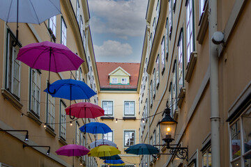 Obraz na płótnie Canvas Umbrellas with different colors hanging in the Courtyard and public passage Suennhof in the 3rd District in Vienna, Austria 