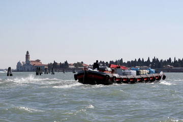 motorboot mit waren vor dem panorama von san michele
