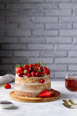 Summer cake with berries on a gray table in the kitchen