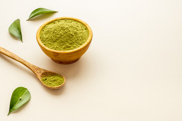 Henna powder in wooden bowl with green leaves. Herbal natural hair dye