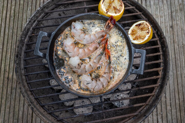 outdoor cooking shrimps on bbq with garlic and lemon