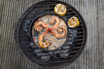 outdoor cooking shrimps on bbq with garlic and lemon
