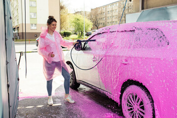 beautiful woman self-service car wash worker washes car