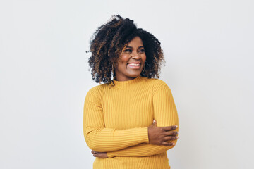 Portrait of smiling beautiful black woman standing against white background with arms folded - Powered by Adobe