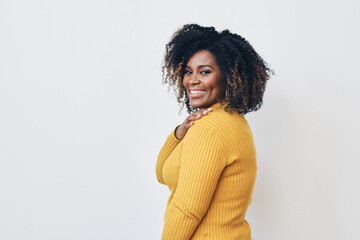 Profile of African American mid aged woman with curly hair and one hand on her shoulder looking at...