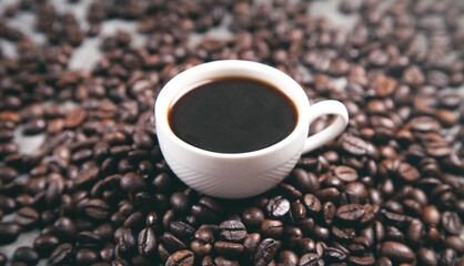 Cup of coffee on coffee beans.