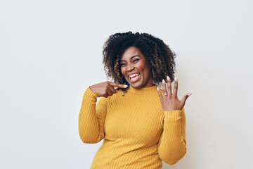 Smiling woman with curly hair showing engagement ring