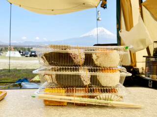 富士山の見えるテントの中に積んだおにぎりのパック