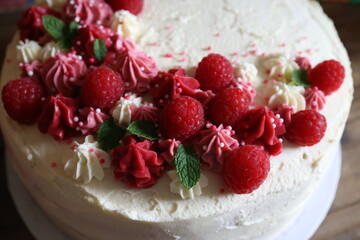 Birthday cake with cream and fresh raspberries