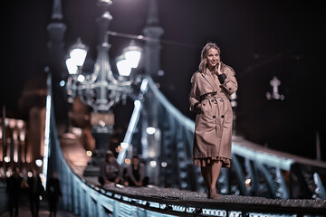 Fototapeta na wymiar girl in a coat, spring glance, night walk in budapest chain bridge landscape