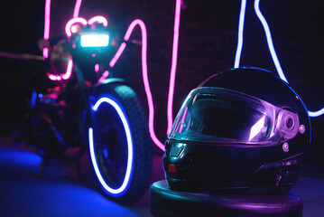 Black motorcycle helmet in the neon lights. Motorbike store showroom concept.