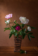 Bouquet of Peonies on brown wooden table.