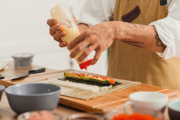 Close up preparing rolls. Chef making sushi with rice and salmon fish. Online food delivery