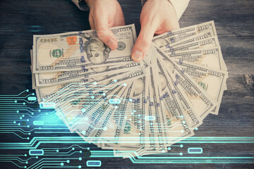 Multi exposure of technology drawing hologram and us dollars bills and man hands. Data concept