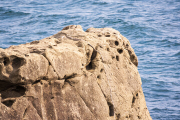 Stone cliff on the sea shore at cloudy day