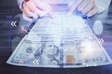 Double exposure of world map drawing hologram and us dollars bills and man hands.