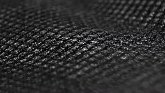 Black mesh textured fabric synthetic wavy surface. Macro. Dolly shot. Abstract texture