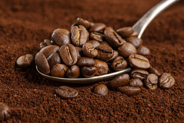 Coffee beans on spoon on coffee background